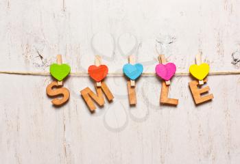 word SMILE of colorful wooden letters on a white background old