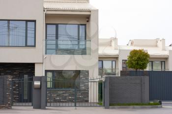 Cottage house behind the fence. Modern exterior of home.Modern stylish facade
