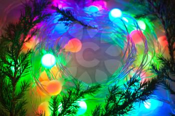 out of focus colored lights and garlands of Christmas tree branches. New Year, Christmas background