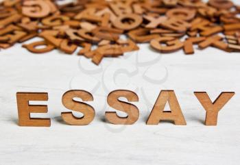 Word Essay made with wooden letters on a background of other blurred letters