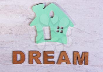 green house and the word dream of letters on a white wooden background