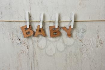 the word baby and clothespins on a white background old,rustic