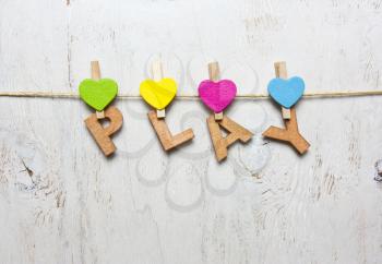 word play with wooden letters on a white background with clothespins