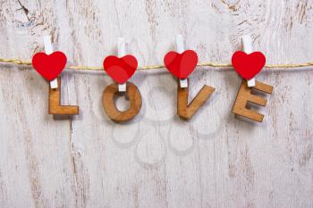 wood letters and heart forming word LOVE  on old wooden white  background