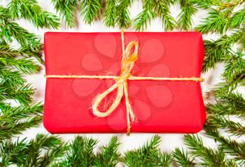 Present in the frame of tree branches. The composition of the Christmas tree and presents in red wrapping paper. Christmas, New Year's background