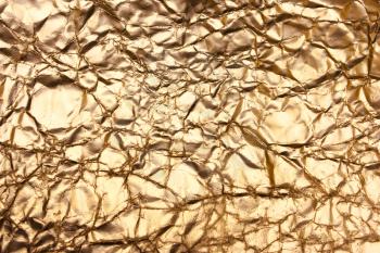 Golden background, shiny creased paper, antique, vintage backdrop. Bronze texture