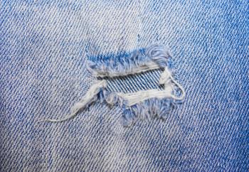 The hole on the blue jeans, denim texture