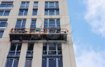 Repair and restoration of a facade of a high building. Workers making repairs on a facade 
