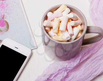 Mug coffee, cocoa with marshmallows and a phone on a white background
