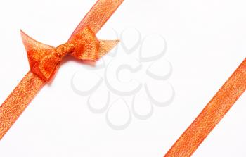 Red golden, orange  ribbons with bow with tails  on white background. The concept of gift, holiday