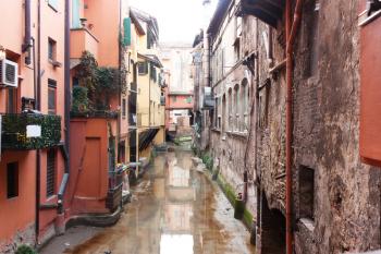 Old water canal hidden behind a window in Bologna  , Italy 