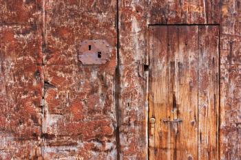 Old door, wood texture with shabby red paint, rust