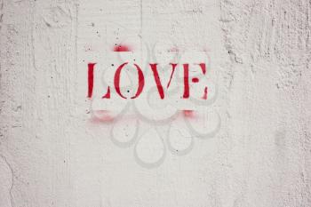 The word love written in red letters on a white wall