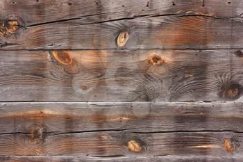 Old, horizontal, wooden, shabby, burnt planks in cracks. Background from the fence, the walls of the house