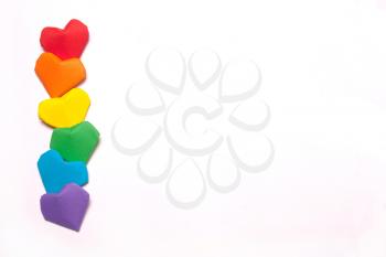 Multicolored paper hearts, a symbol of LGBT, a rainbow flag. Horizontal photo