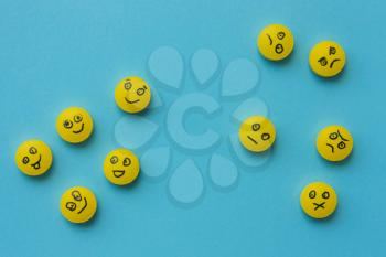 Yellow pills with a smile, on a blue background. Concept, the idea of depression, health, treatment. Top view, flat