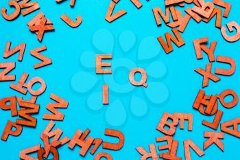 Word EQ,IQ of wooden letters  on a blue background