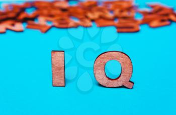 Word ,abbreviation IQ of wooden letters on a blue background