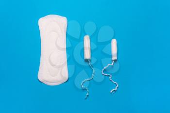 Women's hygiene products, pad, tampon on a blue background. Concept of critical days, menstrual cycle, menstruation