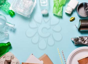 Household waste on a blue background. The concept of sorting plastic, polyethylene cardboard, paper, glass. Protection of the environment, ecology