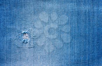 background, texture of denim blue fabric with patch, hole
