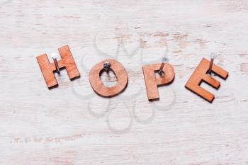 word hope of wooden letters on a white background nailed