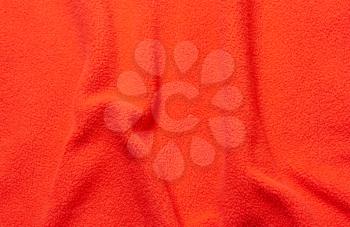 Red soft fleece texture. The surface of a teddy crumpled microfiber rug