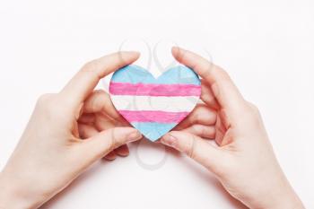 Heart color flag transgender in hand. Pink, white, blue background.