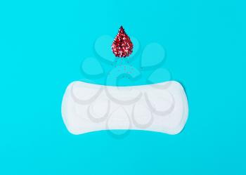 menstrual pads with a drop of blood on a blue background. Concept of critical days,  cycle, menstruation