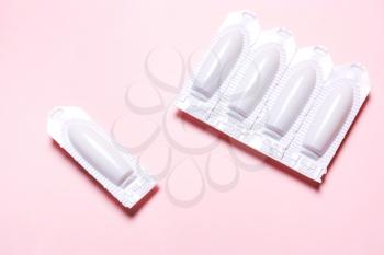 Medical, vaginal suppository on a pink background, for the treatment of hemorrhoids, candidiasis