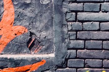 Grunge, gray dark, rough background with orange paint. Brick wall on the street