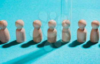 Baby birth concept with test tubes. Artificial insemination. Wooden figures under test tube on a blue background