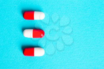 White red capsules, pills on a blue background. Treatment concept
