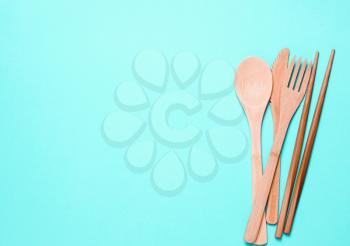 Natural, ecological, Organic wooden fork, spoon, cutlery on a blue background. Concept zero waste, environmental pollution.