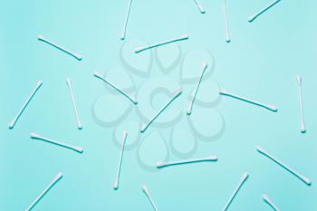White cotton buds on blue background. Concept of cleanliness, makeup, body care. Top view, flat 