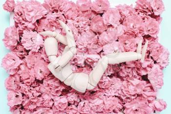 Wooden mannequin on a background of flowers. Depression concept,, sadness, problem