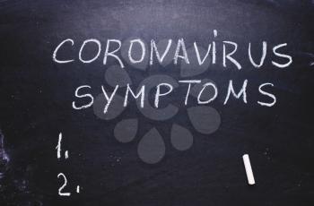 Inscription coronavirus, symptoms on chalk board. Epidemic concept