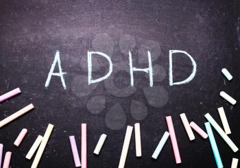The word adhd is written on a chalk board
