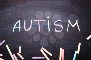 The word autism is written on a chalk board