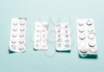 Pills blister pack on a blue background. The concept of disease treatment, healthcare