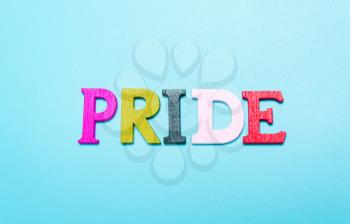 PRIDE word from rainbow color letters on a blue background
