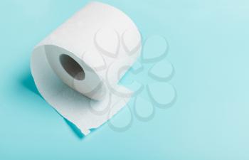 Close-up of white toilet paper on blue background. Top view. The concept of hygiene, cleanliness