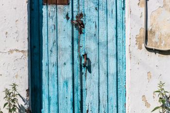 Blue cracked, vintage closed, old door with lock and handle