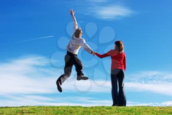 Couple in meadow. Man jump to the sky. Conceptual design.