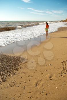 Girl walking on the beach. Peaceful scene.