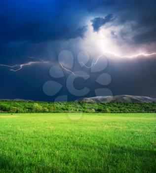 Thunderstorm with lightning  in green meadow. Nature composition.