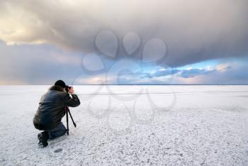 Photographer in work at winter on ice.