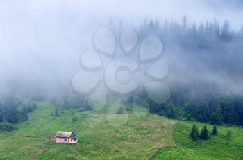 House in mountaun fog. Nature composition.