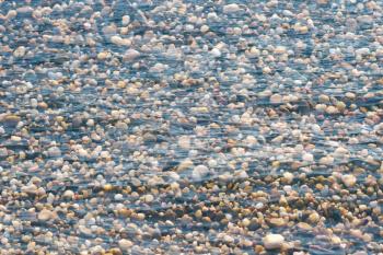 Multiexposure of stones on the beach and sea waves surface.