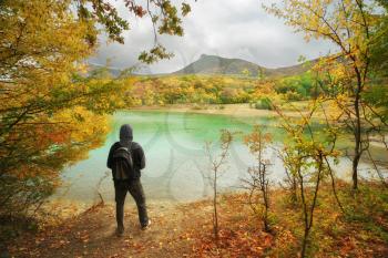 Man standing alone on the pond. Conceptual nature and people scene. Autumn spring tume.